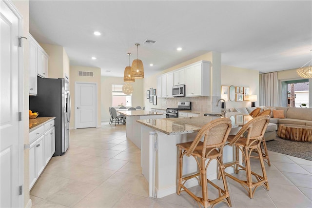 17629 Palmetto Pass Ln, Punta Gorda, FL 33982 - kitchen featuring appliances with stainless steel finishes, a sink, tasteful backsplash, a peninsula, and healthy amount of natural light