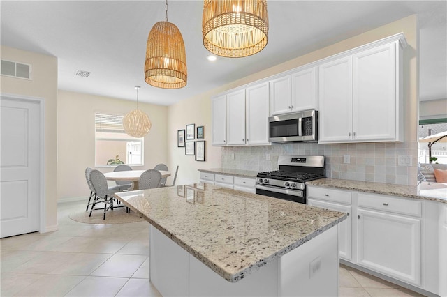 17629 Palmetto Pass Ln, Punta Gorda, FL 33982 - kitchen featuring appliances with stainless steel finishes, decorative backsplash, white cabinetry, and light stone countertops