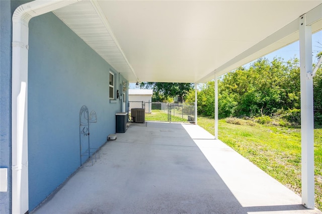 view of patio / terrace featuring central AC, an attached carport, and a gate