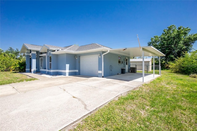 view of front facade with driveway, stucco siding, an attached garage, a carport, and central air condition unit