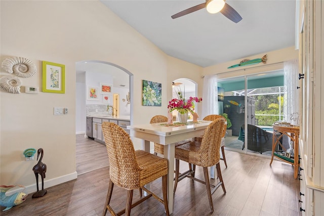 17396 Cox Ave, Port Charlotte, FL 33948 - dining area with arched walkways, lofted ceiling, ceiling fan, wood finished floors, and baseboards