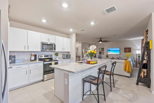 16032 Galiano Ct, Punta Gorda, FL 33955 - kitchen featuring appliances with stainless steel finishes, open floor plan, tasteful backsplash, white cabinetry, and recessed lighting