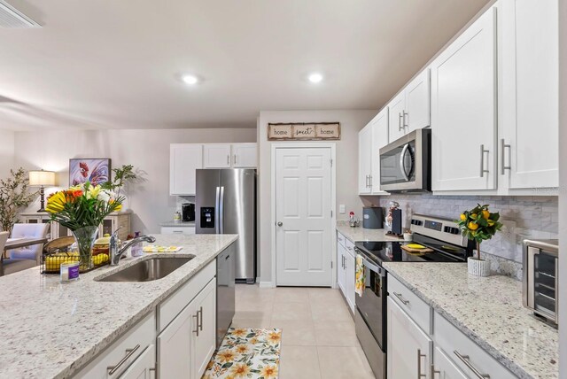 16032 Galiano Ct, Punta Gorda, FL 33955 - kitchen featuring stainless steel appliances, a sink, backsplash, white cabinets, and recessed lighting
