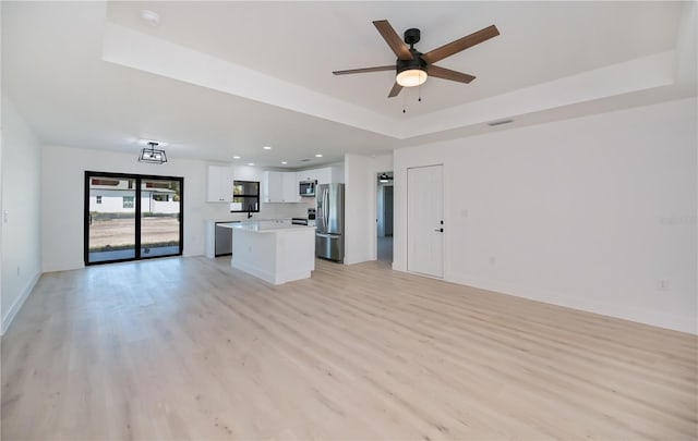 359 Salisbury St, Port Charlotte, FL 33954 - unfurnished living room with a raised ceiling, light wood finished floors, a ceiling fan, baseboards, and recessed lighting