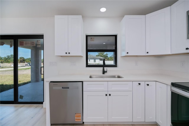 359 Salisbury St, Port Charlotte, FL 33954 - kitchen with stainless steel dishwasher, a sink, healthy amount of natural light, white cabinets, and recessed lighting