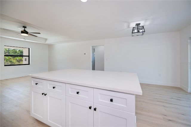 359 Salisbury St, Port Charlotte, FL 33954 - kitchen with a ceiling fan, baseboards, light wood-style floors, white cabinetry, and light countertops