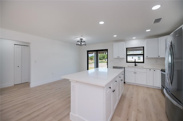 359 Salisbury St, Port Charlotte, FL 33954 - kitchen featuring freestanding refrigerator, a sink, light wood-type flooring, light countertops, and a kitchen island