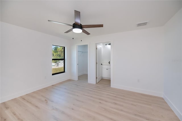 359 Salisbury St, Port Charlotte, FL 33954 - unfurnished bedroom featuring light wood-style floors, baseboards, a walk in closet, and a closet