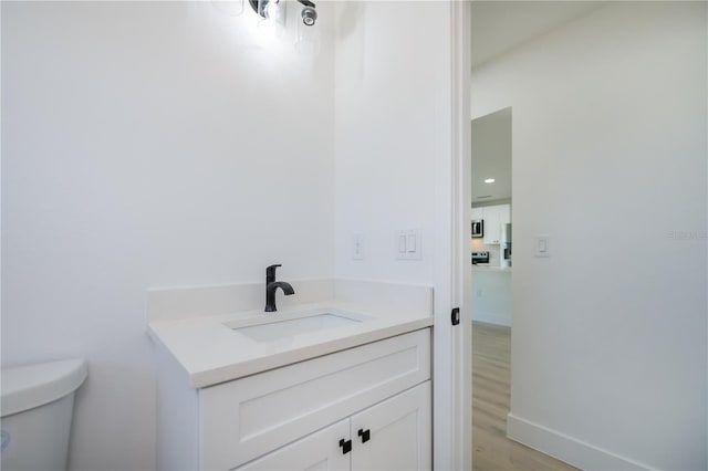 359 Salisbury St, Port Charlotte, FL 33954 - bathroom featuring vanity, toilet, wood finished floors, and baseboards