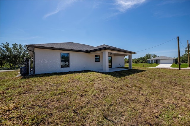359 Salisbury St, Port Charlotte, FL 33954 - rear view of house with a lawn, stucco siding, ceiling fan, a patio, and a detached garage