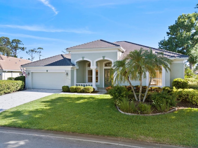 13783 Palmetto Point Ct, Port Charlotte, FL 33953 - mediterranean / spanish-style house with stucco siding, a garage, a tile roof, and a front lawn