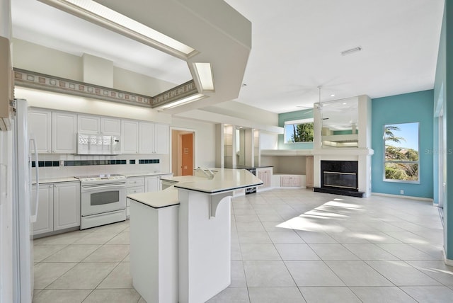 13783 Palmetto Point Ct, Port Charlotte, FL 33953 - kitchen with white appliances, a ceiling fan, light tile patterned floors, and a center island