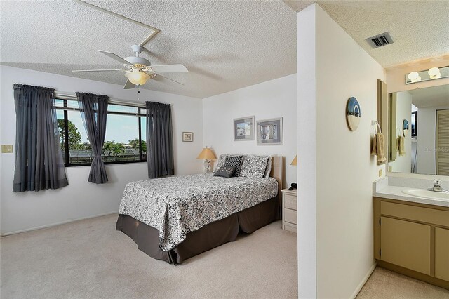 601 Islamorada Blvd Unit 24B, Punta Gorda, FL 33955 - bedroom featuring light colored carpet, a textured ceiling, a sink, a ceiling fan, and baseboards