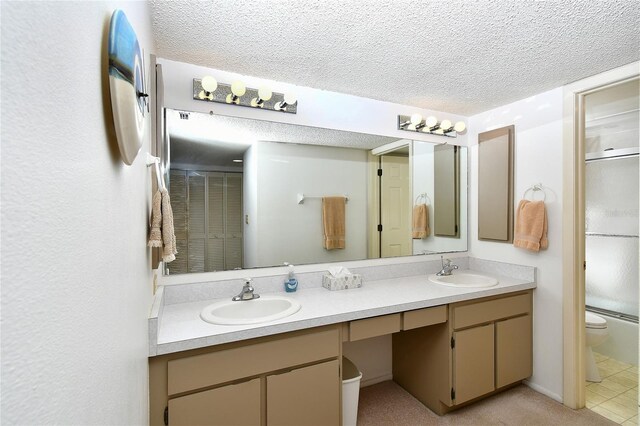 601 Islamorada Blvd Unit 24B, Punta Gorda, FL 33955 - full bath with toilet, double vanity, a textured ceiling, and a shower with door