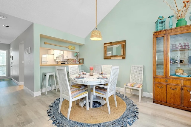 410 Cerromar Cir S Unit 240, Venice, FL 34293 - dining area featuring light wood finished floors, baseboards, and high vaulted ceiling