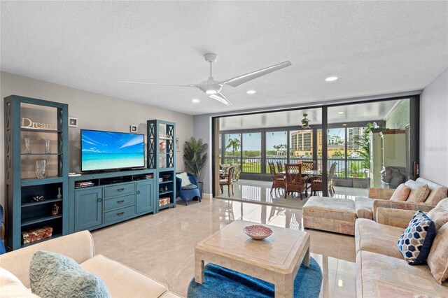 3250 Southshore Dr Unit 54B, Punta Gorda, FL 33955 - living room with a textured ceiling, ceiling fan, expansive windows, recessed lighting, and light tile patterned floors