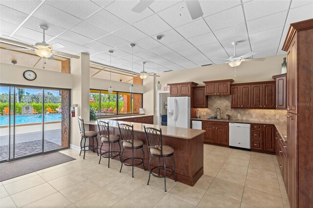 3250 Southshore Dr Unit 54B, Punta Gorda, FL 33955 - kitchen with a ceiling fan, white appliances, a sink, a peninsula, and backsplash