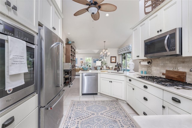 4443 Abcor Rd, North Port, FL 34286 - kitchen with appliances with stainless steel finishes, a peninsula, ceiling fan, white cabinetry, and lofted ceiling