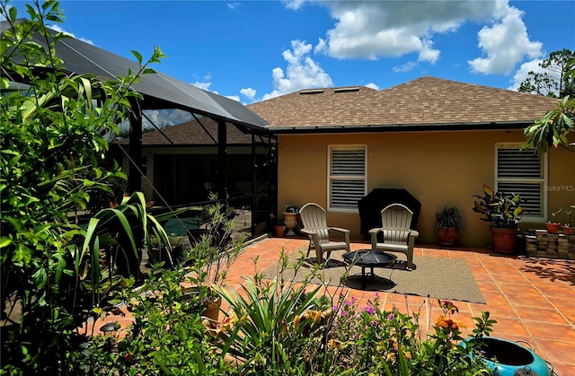 4443 Abcor Rd, North Port, FL 34286 - back of property featuring stucco siding, roof with shingles, a patio area, a fire pit, and glass enclosure