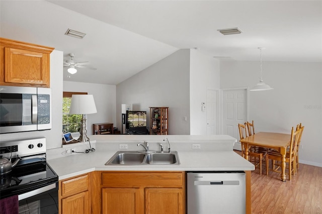 3886 Cincinnati St, North Port, FL 34286 - kitchen with appliances with stainless steel finishes, a sink, a peninsula, vaulted ceiling, and light countertops