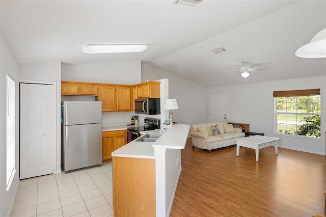 3886 Cincinnati St, North Port, FL 34286 - kitchen featuring stainless steel appliances, open floor plan, vaulted ceiling, light countertops, and a sink