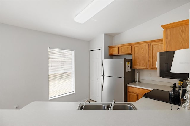 3886 Cincinnati St, North Port, FL 34286 - kitchen with freestanding refrigerator, a sink, light countertops, range, and brown cabinets
