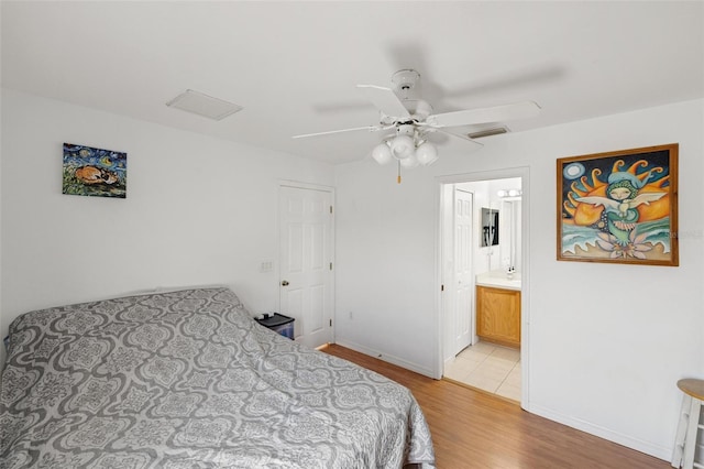 3886 Cincinnati St, North Port, FL 34286 - bedroom with light wood-style floors, baseboards, ceiling fan, and ensuite bathroom