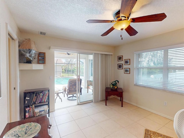 3518 Terin Ct, Punta Gorda, FL 33950 - living area with ceiling fan, baseboards, light tile patterned floors, and a textured ceiling
