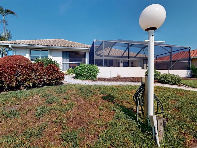 3518 Terin Ct, Punta Gorda, FL 33950 - view of front of house with a tile roof, stucco siding, glass enclosure, a front yard, and ceiling fan