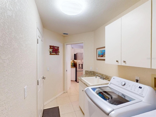 3518 Terin Ct, Punta Gorda, FL 33950 - laundry area with washer / dryer, cabinet space, light tile patterned floors, a textured ceiling, and a textured wall