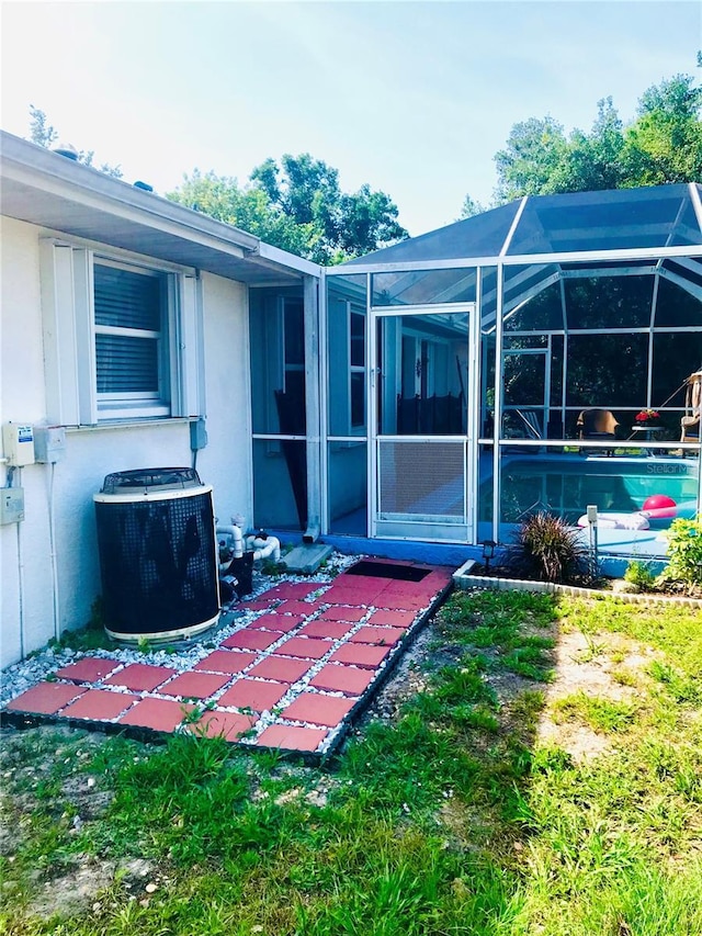 1017 Guild St, Port Charlotte, FL 33952 - back of property featuring central AC, stucco siding, an outdoor pool, and a patio area