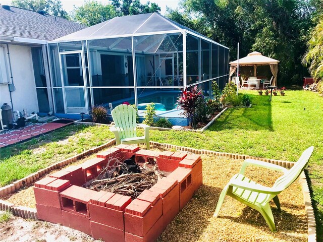 1017 Guild St, Port Charlotte, FL 33952 - back of house with a fire pit, a gazebo, a yard, an outdoor pool, and a patio