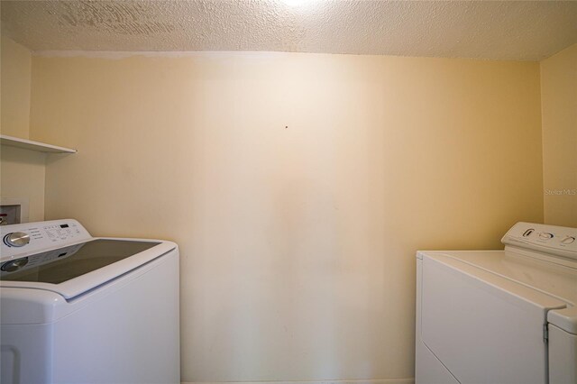 1596 Hayworth Rd, Port Charlotte, FL 33952 - laundry area featuring washing machine and dryer and a textured ceiling