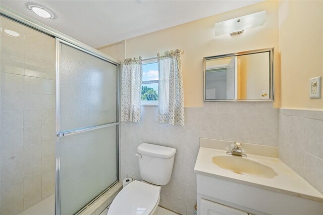1596 Hayworth Rd, Port Charlotte, FL 33952 - full bathroom with a shower stall, toilet, vanity, and tile walls