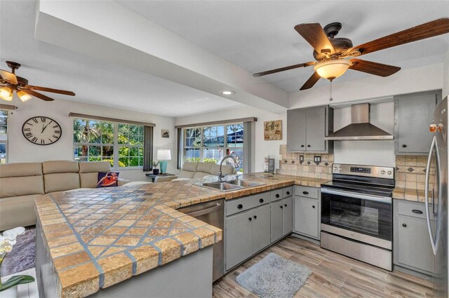 2626 Auburn Blvd, Port Charlotte, FL 33948 - kitchen featuring wall chimney exhaust hood, stainless steel appliances, a ceiling fan, gray cabinets, and a sink
