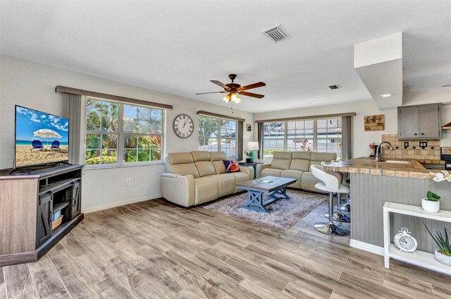 2626 Auburn Blvd, Port Charlotte, FL 33948 - living area featuring light wood finished floors, a ceiling fan, and baseboards