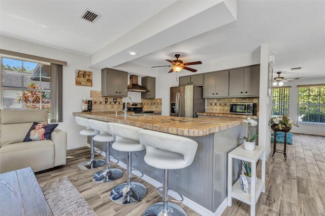 2626 Auburn Blvd, Port Charlotte, FL 33948 - kitchen with appliances with stainless steel finishes, a ceiling fan, gray cabinets, wall chimney exhaust hood, and recessed lighting