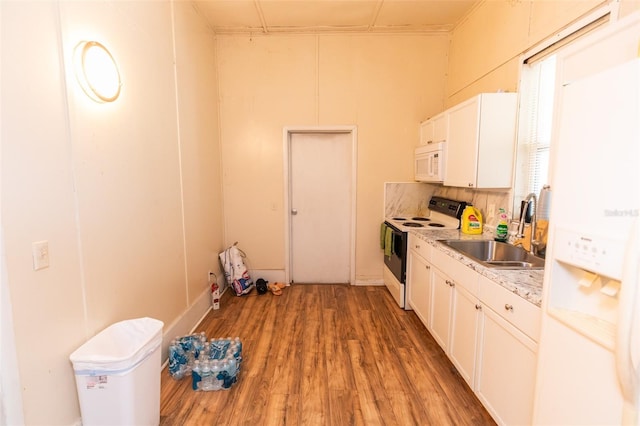 114 N Dade Ave, Arcadia, FL 34266 - kitchen with white appliances, a sink, wood finished floors, white cabinets, and light countertops