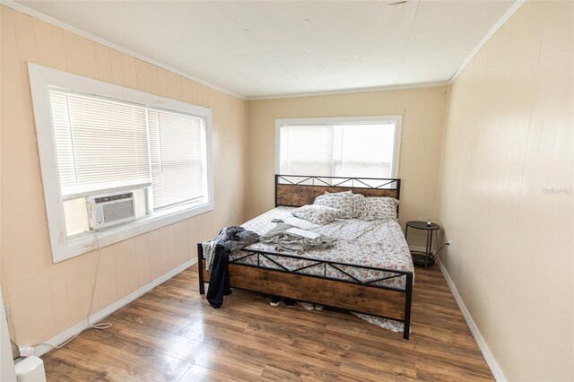 114 N Dade Ave, Arcadia, FL 34266 - bedroom with wood finished floors, crown molding, baseboards, cooling unit, and wooden walls