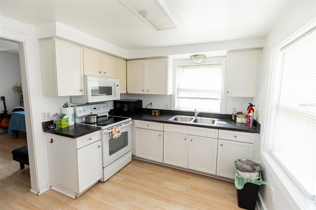 114 N Dade Ave, Arcadia, FL 34266 - kitchen with white appliances, a sink, dark countertops, and light wood finished floors