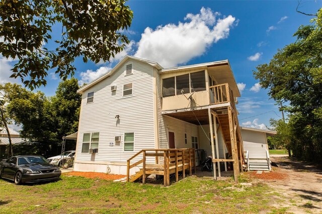 114 N Dade Ave, Arcadia, FL 34266 - rear view of property featuring a sunroom and a wooden deck
