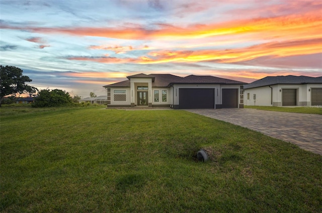 15 Tournament Rd, Rotonda West, FL 33947 - prairie-style home featuring decorative driveway, an attached garage, a front lawn, and stucco siding