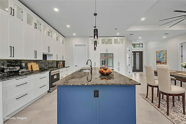15 Tournament Rd, Rotonda West, FL 33947 - kitchen featuring stainless steel appliances, tasteful backsplash, recessed lighting, a kitchen island with sink, and dark stone counters