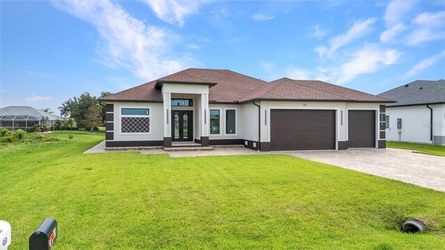 15 Tournament Rd, Rotonda West, FL 33947 - prairie-style house featuring a garage, a front lawn, decorative driveway, french doors, and stucco siding