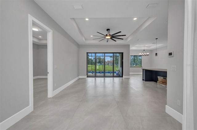 15 Tournament Rd, Rotonda West, FL 33947 - unfurnished living room with a raised ceiling, a ceiling fan, recessed lighting, and a chandelier