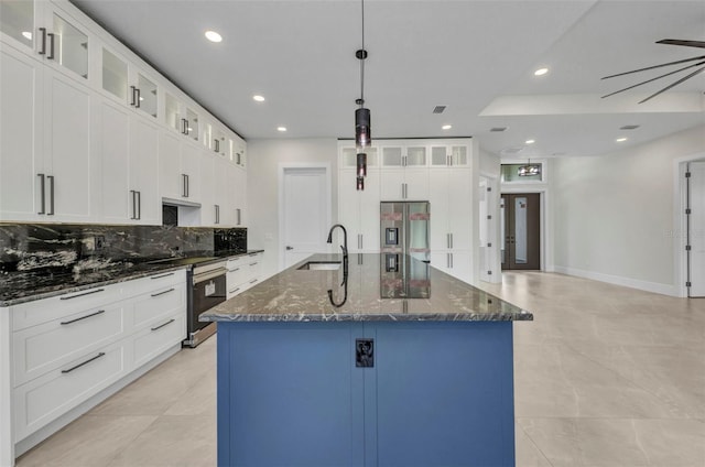15 Tournament Rd, Rotonda West, FL 33947 - kitchen featuring stainless steel fridge, tasteful backsplash, recessed lighting, a center island with sink, and dark stone countertops