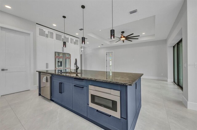 15 Tournament Rd, Rotonda West, FL 33947 - kitchen with appliances with stainless steel finishes, white cabinets, dark stone countertops, glass insert cabinets, and a center island with sink