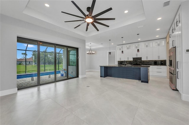 15 Tournament Rd, Rotonda West, FL 33947 - kitchen with a raised ceiling, dark countertops, backsplash, freestanding refrigerator, and a ceiling fan