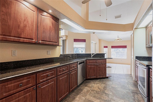 25538 Rampart Blvd, Punta Gorda, FL 33983 - kitchen with stainless steel appliances, a sink, a peninsula, a ceiling fan, and a textured wall
