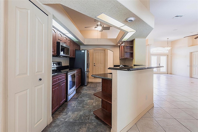 25538 Rampart Blvd, Punta Gorda, FL 33983 - kitchen with open shelves, stainless steel appliances, ceiling fan, dark countertops, and arched walkways